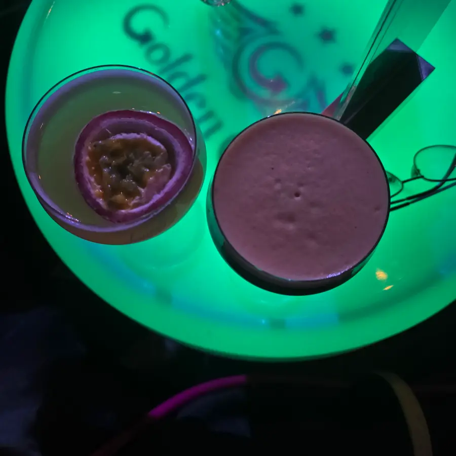 Maracuja-Cocktail von oben auf einem leuchtenden Tisch mit Golden-Club-Logo